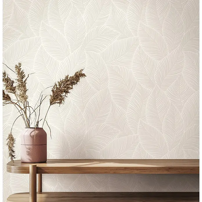 Marburg Novamur Plus Fresh UP Vliestapete Flora VII - Beige, Floral, 10,05 x 0,53 m - Helle beigefarbene Tapete mit zartem Blattmuster, hinter einem Holzregal mit Vase und Trockenpflanzen.