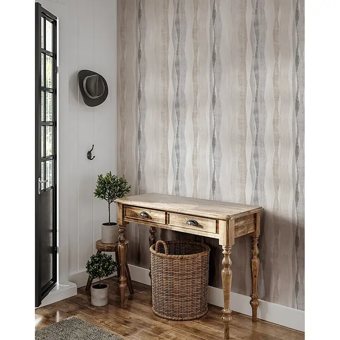 Marburg Novamur Plus Fresh UP Vliestapete Grafik I - Grau, Grafisch, 10,05 x 0,53 m - Hellbrauner Konsolentisch aus Holz mit zwei Schubladen, in einem Flureingang neben Pflanzen und einem geflochtenen Korb.