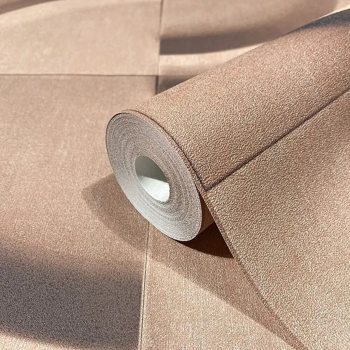 Marburg Shades Iconic Vliestapete Grafik I - Braun, Grafisch, 10,05 x 0,53 m - Teilweise abgerollte, beige strukturierte Tapetenrolle, die ihre inneren Schichten und raue Oberfläche zeigt.
