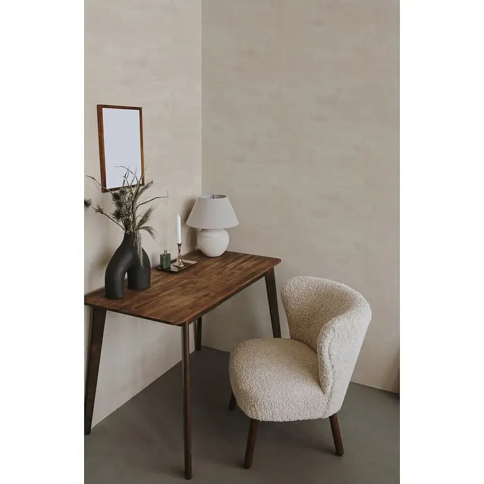 Marburg Novamur Plus Fresh UP Vliestapete Uni - Creme, Uni, 10,05 x 0,53 m - Eine moderne Büroecke mit einem dunklen Holzschreibtisch und einem cremefarbenen Bouclé-Stuhl, dekoriert mit Lampe, Vase und Kerze.