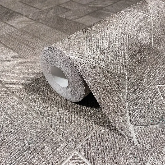 Marburg Ritus Vliestapete Grafik I - Silber-Grau, Grafisch, 10,05 x 0,53 m - Rolle strukturierter silbergrauer Tapete mit schimmerndem geometrischem Mosaikmuster, teilweise ausgerollt.