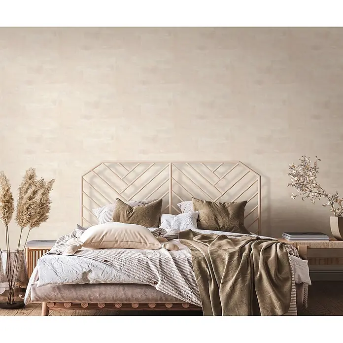 Marburg Novamur Plus Fresh UP Vliestapete Uni - Creme, Uni, 10,05 x 0,53 m - Ein Bohème-Schlafzimmer mit einem Bett, das ein helles geometrisches Holzkopfteil und geschichtete Bettwäsche in neutralen, erdigen Tönen für Komfort aufweist.