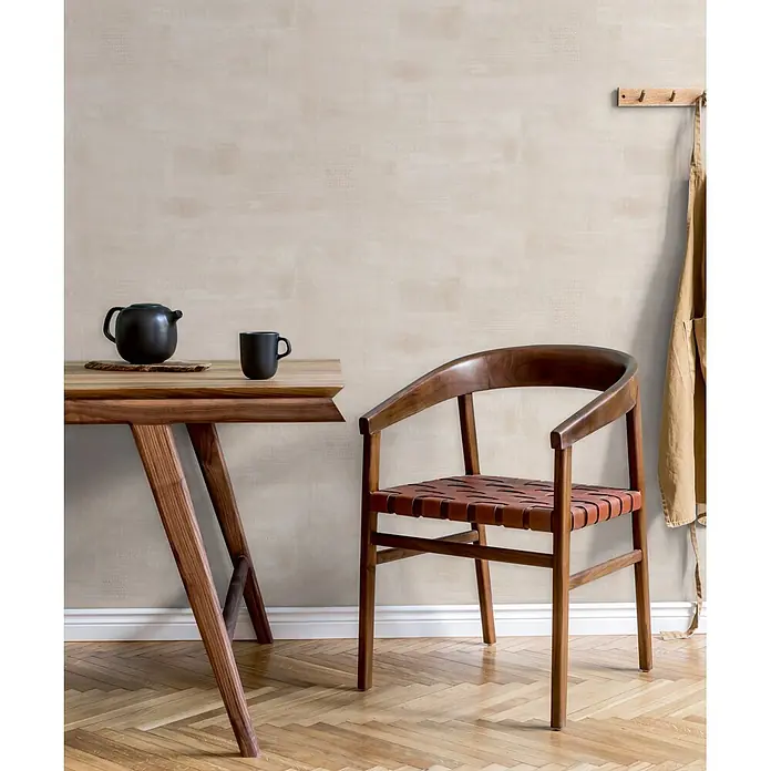 Marburg Novamur Plus Fresh UP Vliestapete Uni - Grau-Beige, Uni, 10,05 x 0,53 m - Holztisch mit schwarzer Teekanne und Tasse, dazu Holz-Ledersessel in natürlichem Raum mit Schürze.