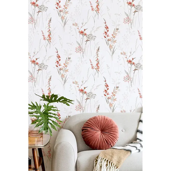 Marburg Novamur Plus Fresh UP Vliestapete Floral I - Weiß-Rot, Floral, 10,05 x 0,53 m - Plissiertes altrosa Rundkissen auf einem hellgrauen Sofa, mit beiger Decke, in einem stilvollen Wohnzimmerambiente.