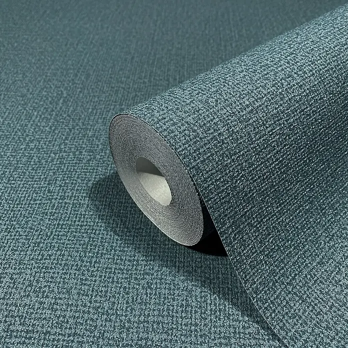 Marburg Kumano Vliestapete - Blau, Uni, 10,05 x 0,53 m - Teilweise abgerollte dunkelpetrolfarbene Tapetenrolle mit gewebtem Muster.