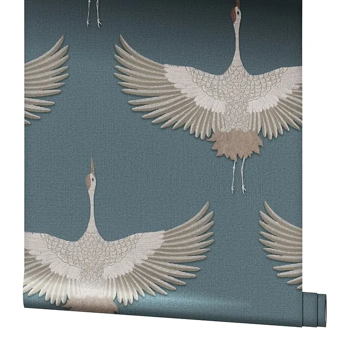 Marburg Kumano Vliestapete Grafik - Blau, Grafisch, 10,05 x 0,53 m - Tapetenrolle mit blau-grauem Hintergrundmuster und weißen, hellbraunen Kranichen mit ausgebreiteten Flügeln.