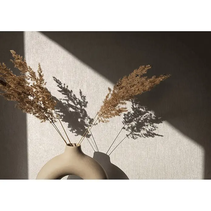 Marburg Ritus Vliestapete Uni - Beige, Uni, 10,05 x 0,53 m - Getrocknetes Pampasgras in einer modernen beigefarbenen Donut-Vase, die komplizierte Schatten auf eine strukturierte Wand wirft.