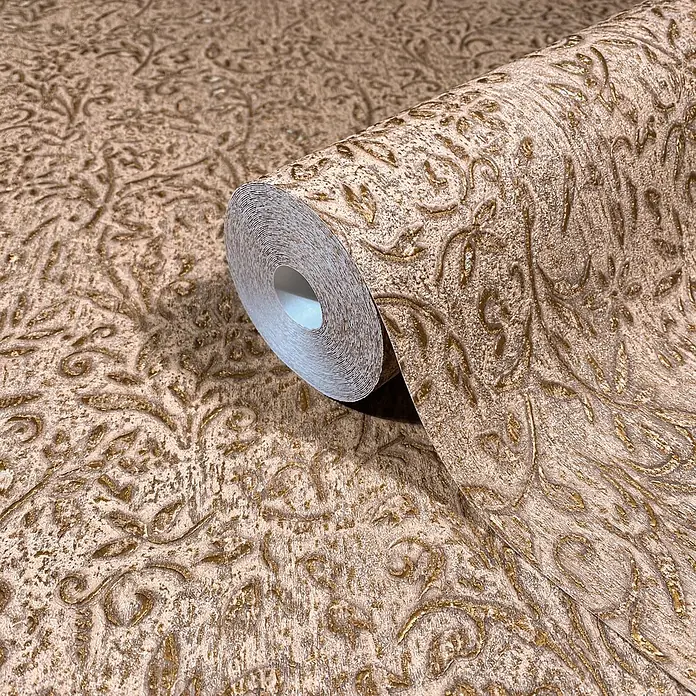 Marburg Ritus Vliestapete Floral - Braun-Gold, Floral, 10,05 x 0,53 m - Teilweise abgerollte beige Tapetenrolle mit geprägtem goldenem Blumen- und Rankenmuster.