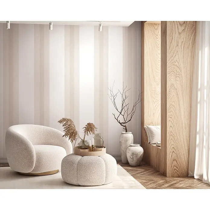 Marburg Vliestapete Novamur Oriana Streifen - Beige, Streifen, 10,05 x 0,53 m - Moderner cremefarbener Sessel und passender Pouf als Beistelltisch in einem hellen Wohnzimmer.