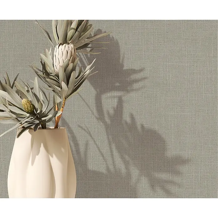 Marburg Boho Vliestapete Uni II - Grün-Braun, Uni, 10,05 x 0,53 m - Eine cremefarbene, skulpturale Vase mit zwei Protea-Blüten, einer geöffneten und einer Knospe, wirft Schatten.