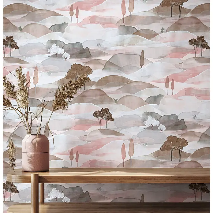 Marburg Boho Vliestapete Landscape - Blau-Rot, Sonstiges, 10,05 x 0,53 m - Ein Holzregal mit einer rosa Vase voller getrocknetem Pampasgras, vor einer Tapete mit abstrakt gemalten Hügeln und Bäumen.