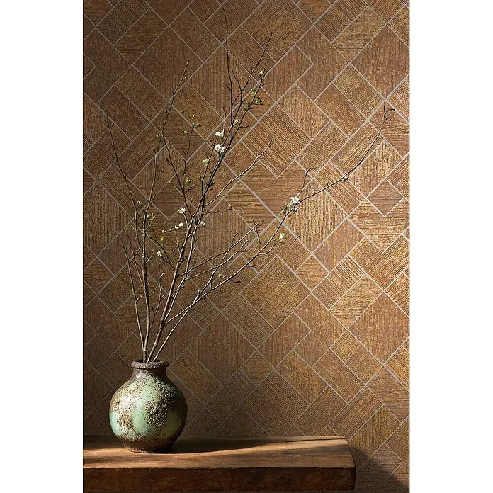 Marburg Ritus Vliestapete Grafik I - Gold, Grafisch, 10,05 x 0,53 m - Eine strukturierte grünblaue Vase mit Ästen, kleinen weißen Blüten und grünen Knospen steht auf einem Holztisch vor einer gemusterten Wand.