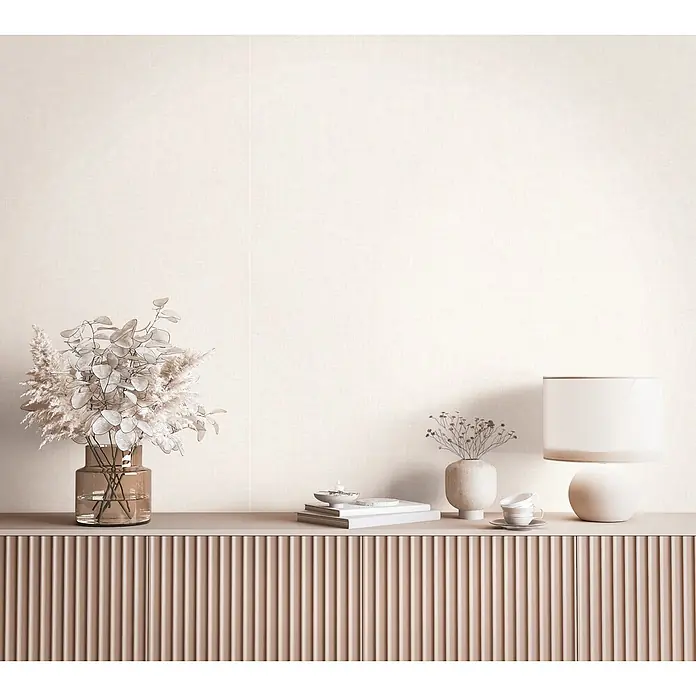 Marburg Boho Vliestapete Uni - Beige-Braun, Uni, 10,05 x 0,53 m - Hellbeigefarbene strukturierte Tapete in einem Wohnraum, über einem geriffelten Schrank mit Dekorationsartikeln.