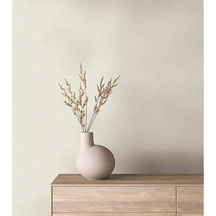 Marburg Ritus Vliestapete Putzoptik - Beige, Sonstiges, 10,05 x 0,53 m - Hellbeige strukturierte Wandverkleidung in einem modernen Raum, hinter einem Holzschrank und einer rosa Vase.