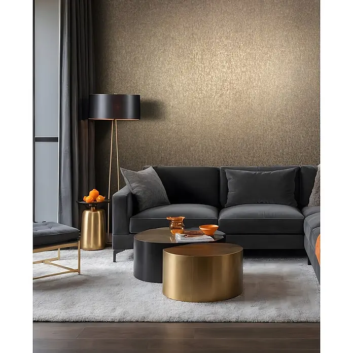 Marburg Ritus Vliestapete Uni - Kupfer, Uni, 10,05 x 0,53 m - Dunkelgraues Sektionssofa mit Kissen in einem modernen Wohnzimmer, ergänzt durch goldene Couchtische und Struktur-Tapete.
