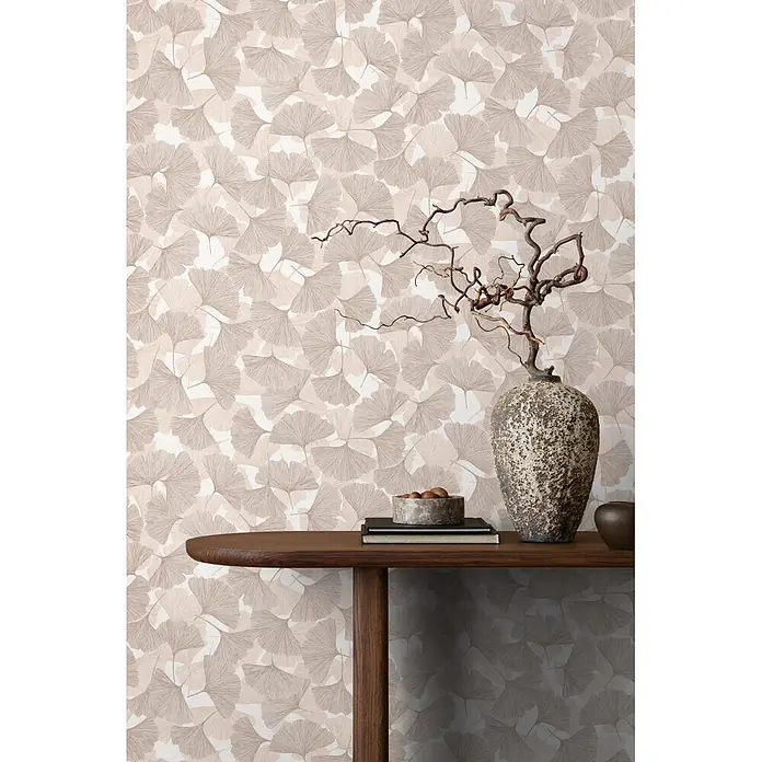 Marburg Boho Vliestapete Floral - Beige-Braun, Floral, 10,05 x 0,53 m - Beige und taupefarbene Ginkgo-Blatt-Tapete an einer Wand, hinter einem Holz-Konsolentisch mit Dekoration.