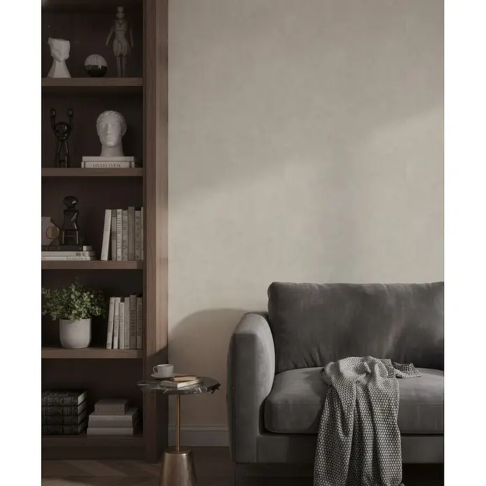 Marburg Whisper Vliestapete Putzoptik I - Taupe, Sonstiges, 10,05 x 0,53 m - Dunkelgraues Sofa mit strukturierter Decke in einem Wohnzimmer neben einem Holzregal und Beistelltisch.