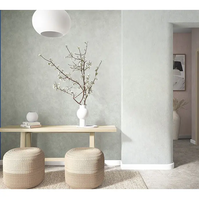 Marburg Whisper Vliestapete Putzoptik I - Grün, Sonstiges, 10,05 x 0,53 m - Zwei geflochtene beigefarbene Poufs unter einem Holzkonsolentisch in einem modernen Interieur.