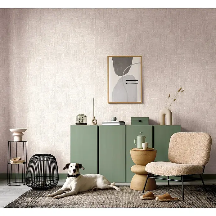 Marburg Vliestapete Novamur Naomi Streifen - Beige, Streifen, 10,05 x 0,53 m - Moderner Wohnbereich mit Hund auf Teppich, salbeigrüner Kommode, cremefarbenem Bouclé-Sessel und Holztisch vor einer strukturierten beigefarbenen Wand.
