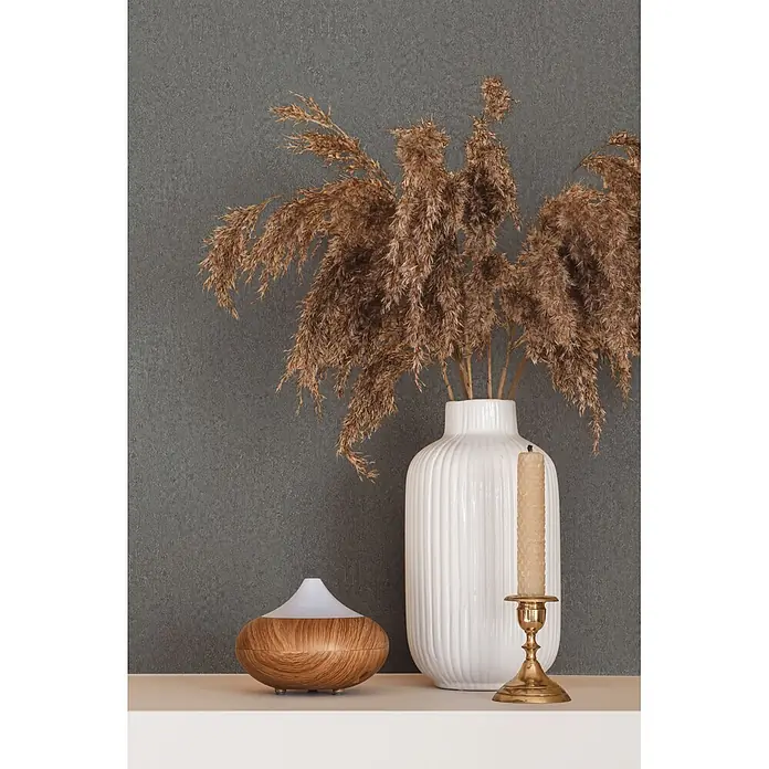 Marburg Ritus Vliestapete Putzoptik I - Anthrazit, Sonstiges, 10,05 x 0,53 m - Aroma-Diffusor mit Holzbasis und weißer Oberseite, weiße gerippte Vase mit Pampasgras, Messing-Kerzenhalter mit Bienenwachskerze auf weißem Regal.