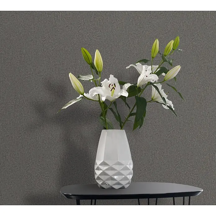 Marburg Ritus Vliestapete Putzoptik I - Anthrazit, Sonstiges, 10,05 x 0,53 m - Weiße geometrische Vase mit Lilien auf einem dunklen Tisch.