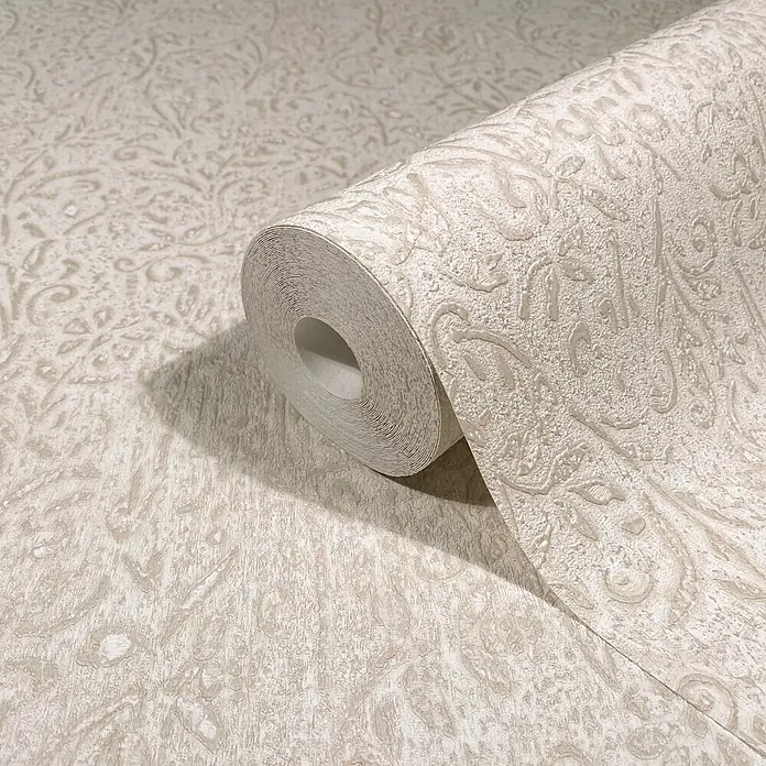 Marburg Ritus Vliestapete Floral - Beige, Floral, 10,05 x 0,53 m - Helle beigefarbene strukturierte Tapetenrolle mit dezentem Damastmuster, teilweise ausgerollt auf passendem Untergrund.