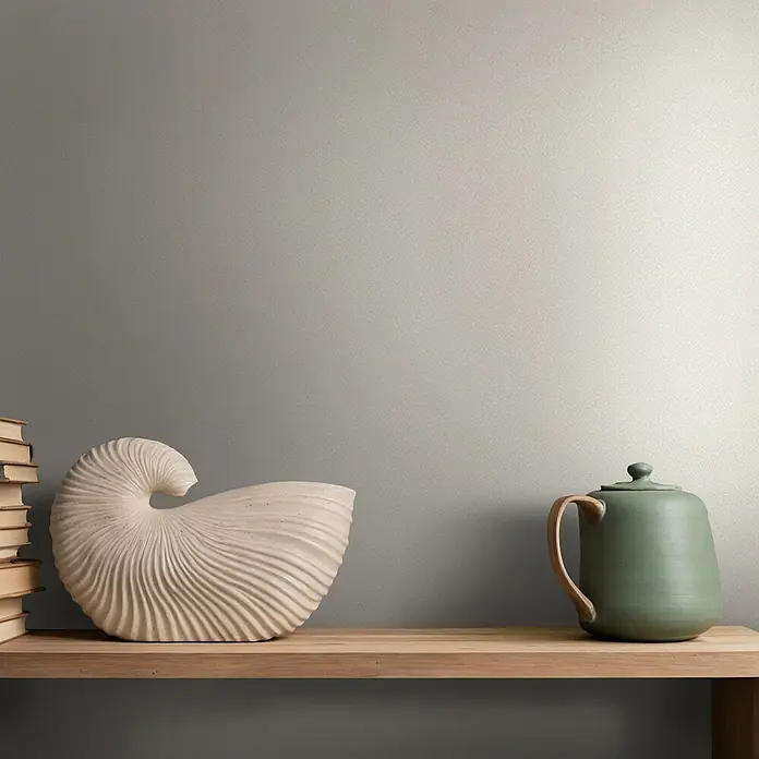 Marburg Vliestapete Novamur Oriana Uni - Beige, Uni, 10,05 x 0,53 m - Helles Holzregal mit cremefarbener Nautilus-Skulptur, gestapelten Büchern und grüner Teekanne als stilvolle Heimdekoration.