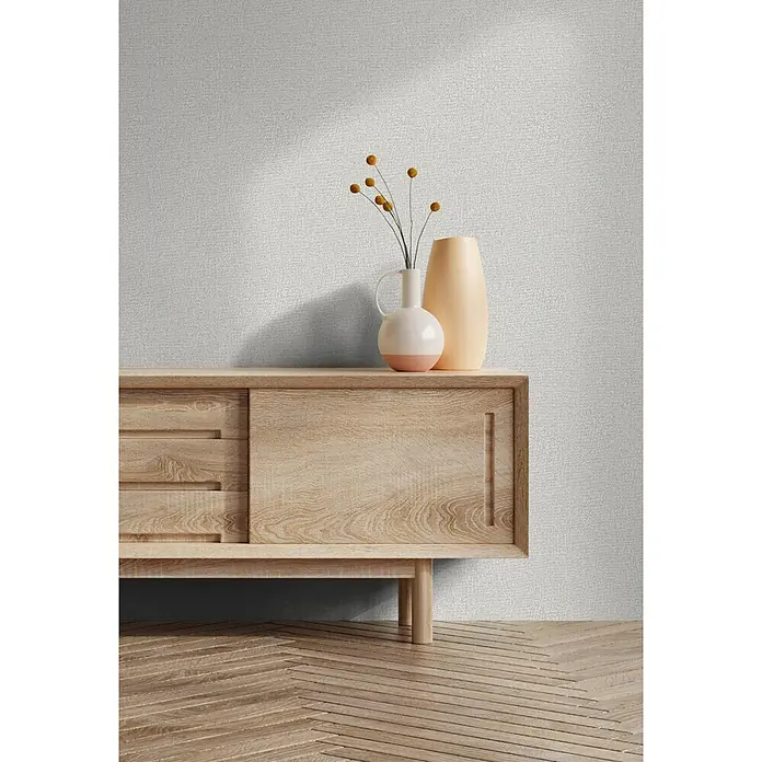 Marburg Ritus Vliestapete Putzoptik - Grau-Beige, Sonstiges, 10,05 x 0,53 m - Helles Holz-Sideboard mit Vasen vor einer strukturierten Wand und Holzfußboden.