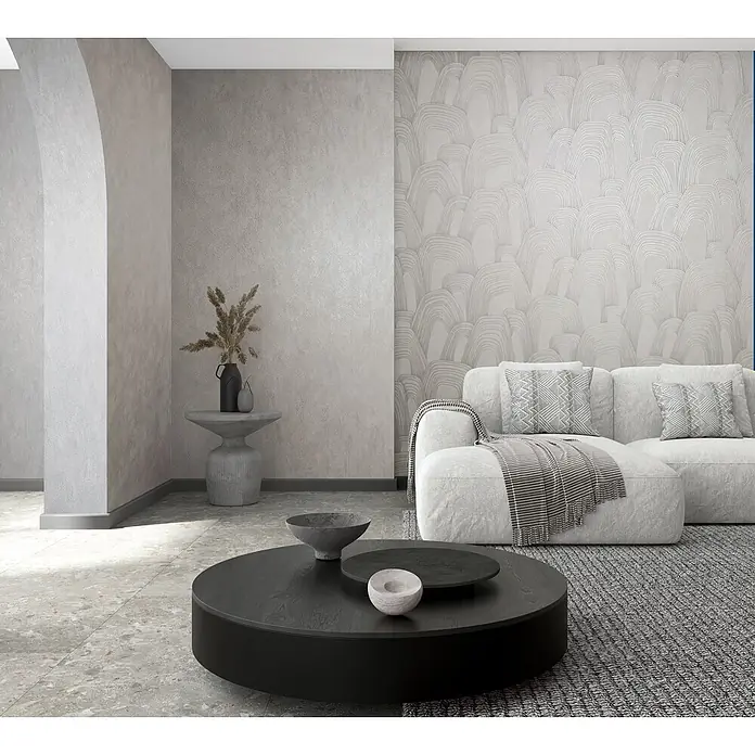 Marburg Whisper Vliestapete Grafik - Grau, Grafisch, 10,05 x 0,53 m - Modernes Wohnzimmer mit weißem Ecksofa, gemusterter Wand, dunklem Couchtisch und strukturiertem Teppich.