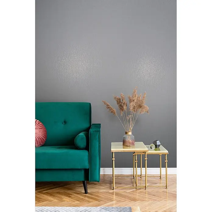 Marburg Vliestapete Novamur Naomi Uni II - Grau, Uni, 10,05 x 0,53 m - Smaragdgrünes Samtsofa neben goldenen Beistelltischen mit Trockenblumen, in einem modernen Wohnzimmer.