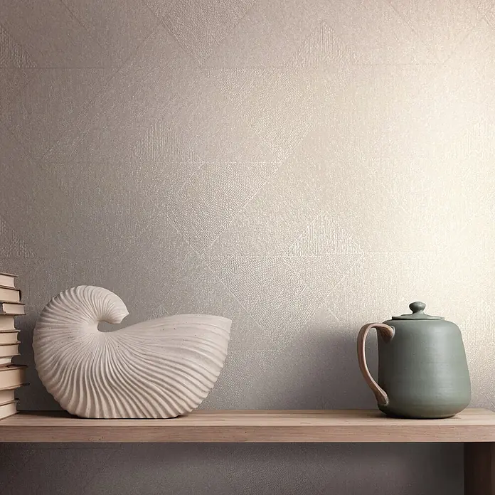 Marburg Vliestapete Novamur Naomi Grafik I - Beige, Grafisch, 10,05 x 0,53 m - Strukturierte hellbeige Wandverkleidung mit subtilem geometrischem Muster, die als stilvolle Kulisse für ein Regal dient.