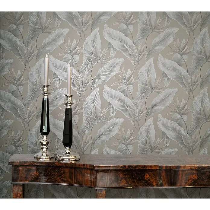 Marburg Whisper Vliestapete Floral - Beige-Grau, Floral, 10,05 x 0,53 m - Zwei elegante Kerzenleuchter mit silbernen Füßen und schwarzen, facettierten Stielen, bestückt mit hellen Kerzen, auf einem polierten dunklen Konsolentisch.