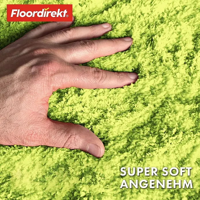Floordirekt Badteppich Sky - 95 x 95 cm, Apfelgrün, 100% Polyester - Eine Hand drückt in einen flauschigen, limettengrünen Teppich, der seine superweiche Textur hervorhebt.