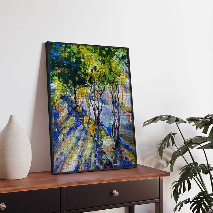 Accent Alurahmen Puzzle Frame - 50 x 70 cm, Schwarz - Ein gerahmtes Puzzle mit einem lebhaften, impressionistischen Gemälde sonnenbeschienener Bäume, das auf einem Holztisch lehnt.