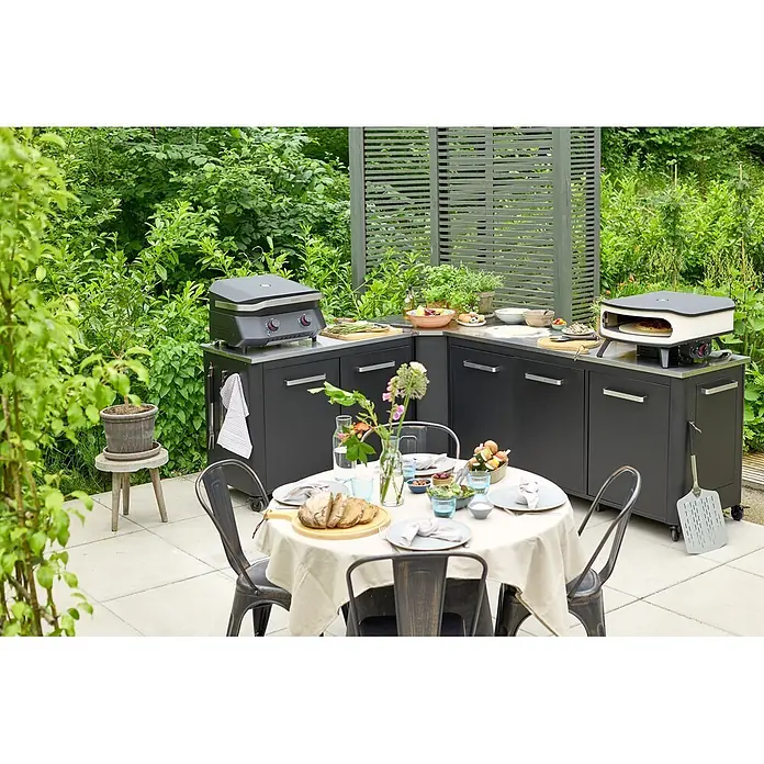 Cozze Outdoorküchen-Modul - Schwarz, B x T x H: 180 x 60 x 90 cm - Kompakte dunkelgraue Außenküche mit Grill und Pizzaofen, zum Kochen und Essen im Freien auf einer Terrasse.
