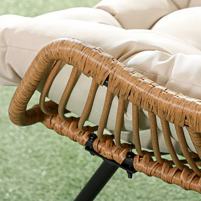 Outsunny Garten-Loungesessel - 1 Stk., Khaki - Nahaufnahme einer Stuhllehne mit hellbraunem Polyrattan-Geflecht und plüschigen beigen Kissen auf einem schwarzen Metallgestell.