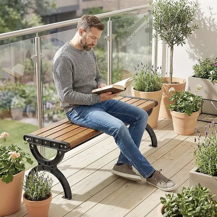 Outsunny Gartenbank - B x T x H: 39 x 39 x 39 cm, Metall, Braun - Gartenbank aus Holz mit dunklen Metallbeinen auf einem Balkon. Ein Mann sitzt darauf und liest ein Buch.
