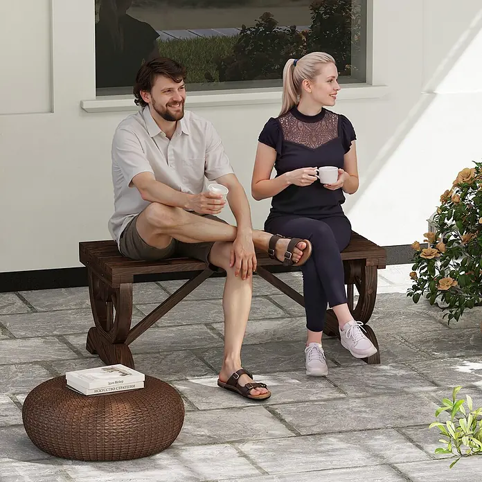Outsunny Gartenbank - Tannenholz, Braun - Dunkle Holzbank mit zwei entspannenden Personen und ein geflochtener brauner Ottoman mit Büchern auf einer Terrasse.