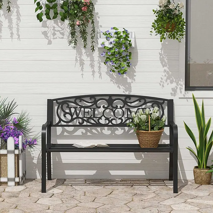 Outsunny Gartenbank - Eisen, pulverbeschichtet, Schwarz - Schwarze Metall-Gartenbank mit dekorativer "WELCOME"-Rückenlehne, auf einer Terrasse mit Buch und Blumen.