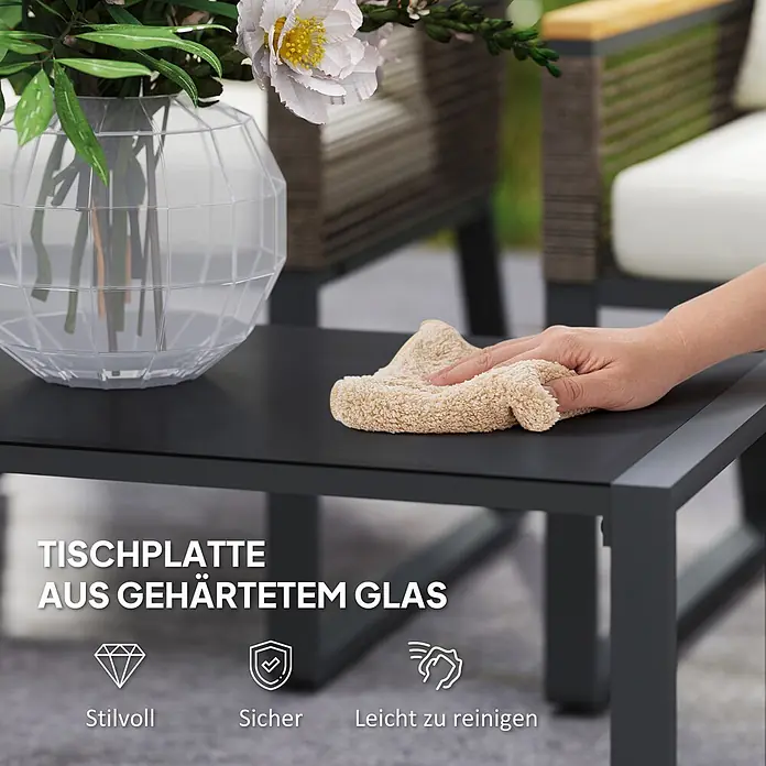 Outsunny Loungemöbel-Set - 4 -tlg., Stahl, PE-Rattan, Polyester, Hartglas, Polystyrol, Sitzkissen, Grau - Eine Hand wischt einen dunkelgrauen Gartentisch mit gehärteter Glasplatte ab. Der Tisch ist stilvoll, sicher und leicht zu reinigen.