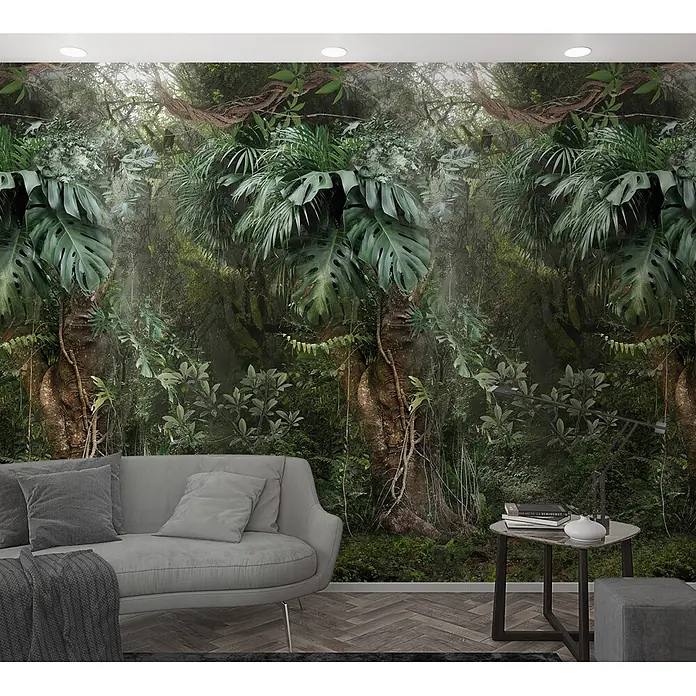 Marburg Smart Art Easy Fototapete Dschungel - B x H: 159 mm x 270 cm, Vlies - Eine lebendige Dschungeltapete bedeckt eine Wohnzimmerwand mit üppigem Grün, Bäumen und Ranken hinter einem grauen Sofa und Beistelltisch.