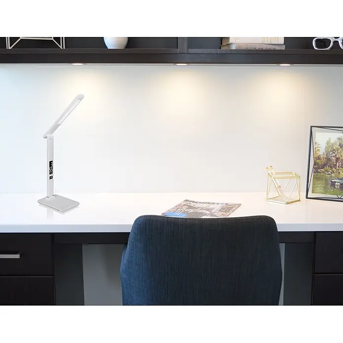 Globo LED-Tischleuchte Tanna - 7 W, L x B x H: 55 x 14 x 59 cm, Weiß, Kaltweiß - Weiße LED-Schreibtischlampe mit Digitalanzeige und verstellbarem Arm neben einem Stuhl.