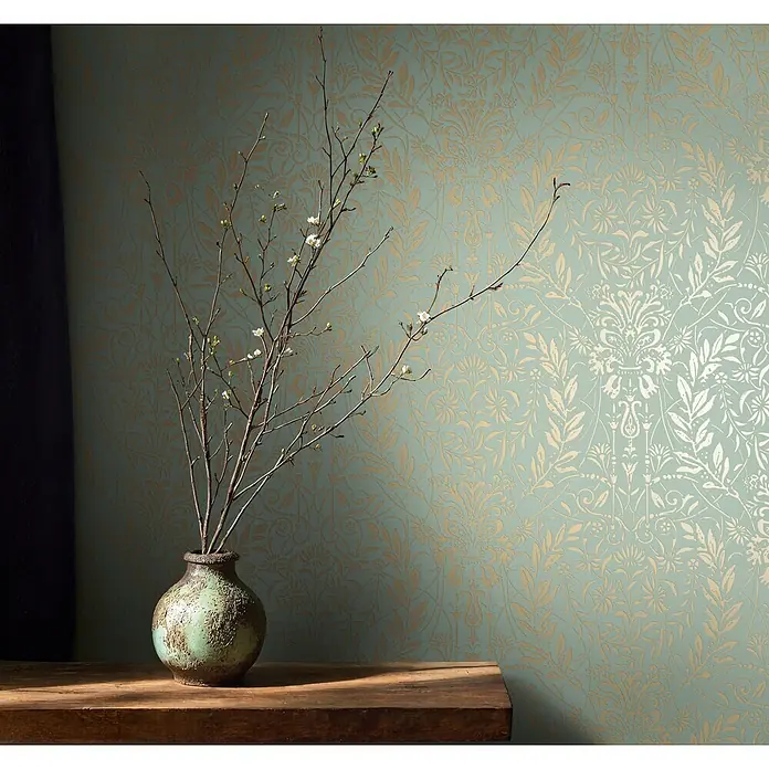 Marburg Vliestapete Novamur Oriana Floral I - Grün, Floral, 10,05 x 0,53 m - Tapete in hellem Türkis mit goldenem Blumen- und Damastmuster, an einer Wand hinter einer Vase mit Zweigen.