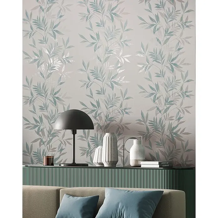 Marburg Vliestapete Novamur Mona Floral - Weiß-Grün, Floral, 10,05 x 0,53 m - Helle Tapete mit einem Muster aus grünen und grauen Blättern, die eine Wand über einer grünen Konsole und einem Sofa schmückt.