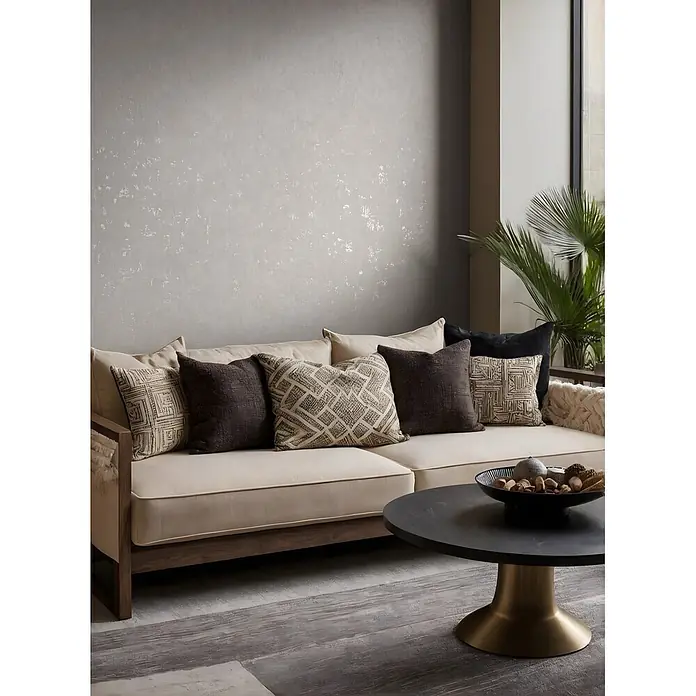 Marburg Vliestapete Novamur Naomi Putzoptik - Grau, Sonstiges, 10,05 x 0,53 m - Ein cremefarbenes Sofa mit dunklem Holzrahmen, verziert mit gemusterten und dunklen Kissen, in einem modernen Wohnzimmer.