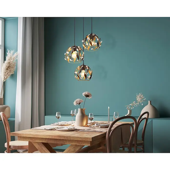 Globo Pendelleuchte Mika - 40 W, Ø x H: 4 x 150 cm, E27 - Drei kunstvolle Pendelleuchten aus Metall mit Blattdesign und Kristallen hängen über einem Holztisch und beleuchten den Esstisch.