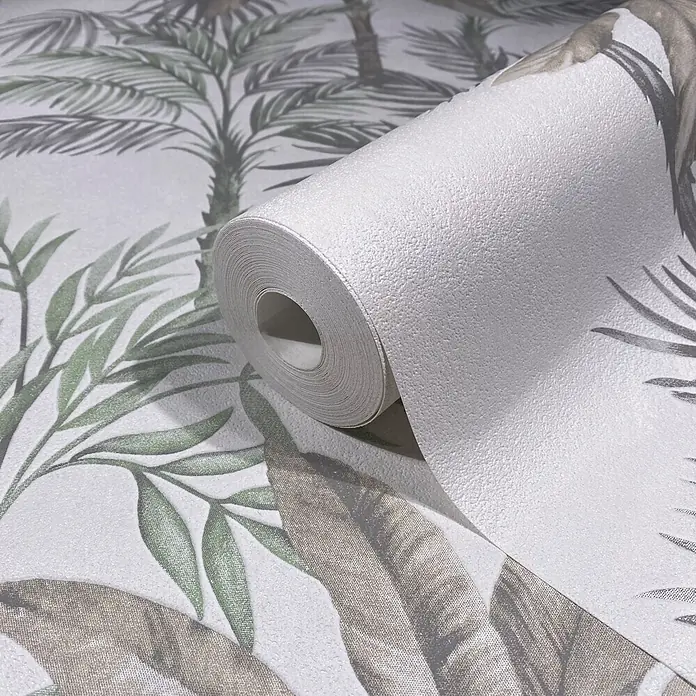 Marburg Vliestapete Novamur Leyla Floral I - Grau-Grün, Floral, 10,05 x 0,53 m - Strukturierte Tapetenrolle mit tropischem Palmen- und Blattmuster in Grün und Taupe, teilweise abgerollt, um ihr Design zu zeigen.