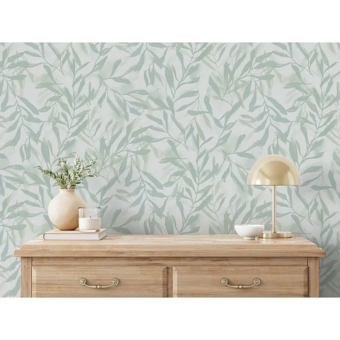 Marburg Vliestapete Novamur Leyla Floral - Weiß-Grün, Floral, 10,05 x 0,53 m - Helle Holzkommode mit Dekoartikeln: Vase, Kerze, Buch, Lampe und Schale.