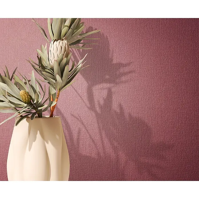 Marburg Vliestapete Novamur Mona Uni - Rot, Uni, 10,05 x 0,53 m - Cremefarbene Vase mit Protea-Blumen vor einer strukturierten weinroten Wand.