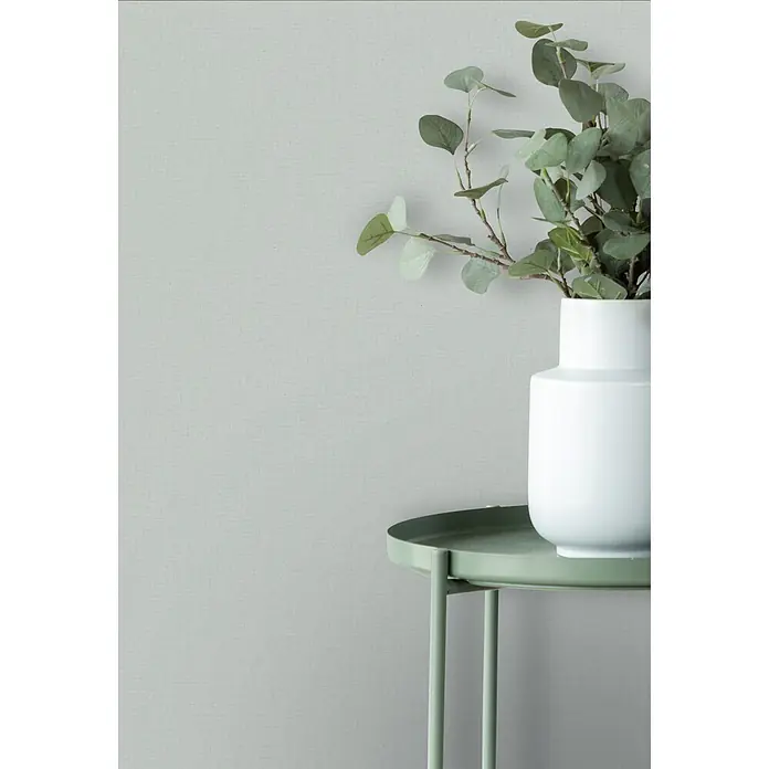 Marburg Vliestapete Novamur Oriana Uni I - Grau, Uni, 10,05 x 0,53 m - Weißer Vase mit Eukalyptus auf einem runden grünen Metallbeistelltisch.